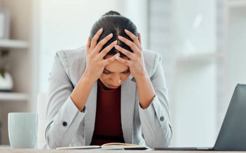 Headache, stress and worried young businesswoman tired from getting bad news about company investment. Professional finance  business female or accountant upset over financial problem or crisis.