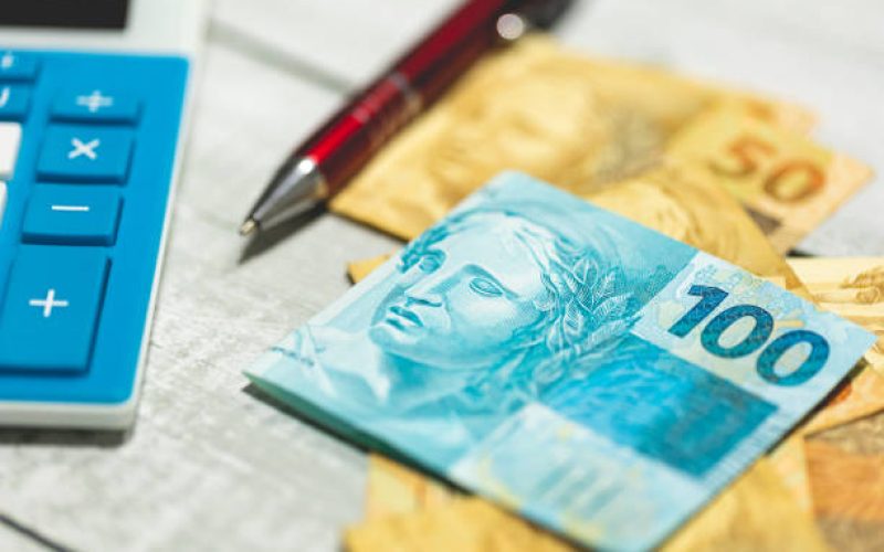 Brazilian Real banknotes and a calculator on a wooden table. Brazilian economy and inflation.