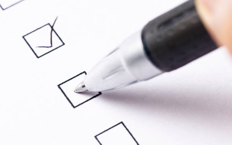 Writing a check mark with ball point pen.